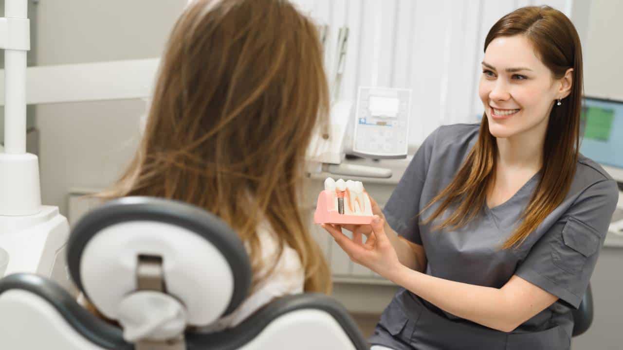 dentist showing dentures to her patient